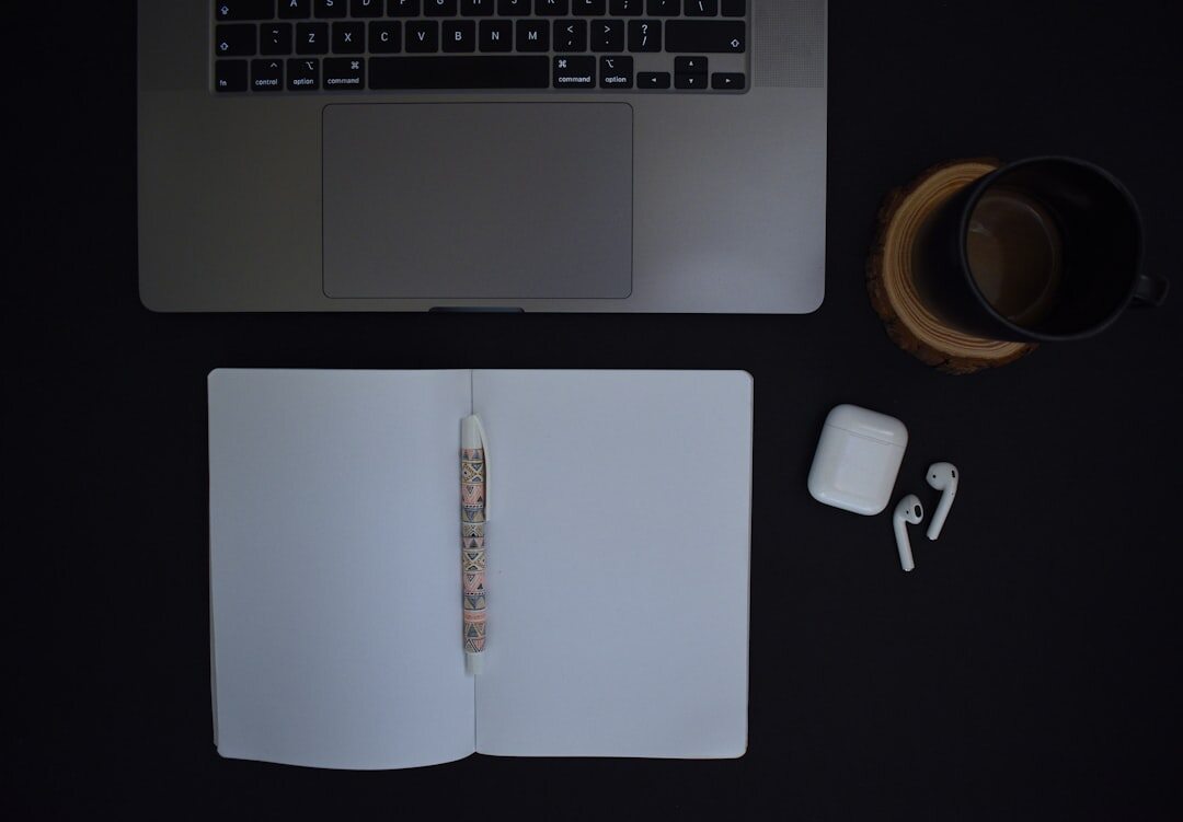 Desk with laptop, notebook and coffee cup from above